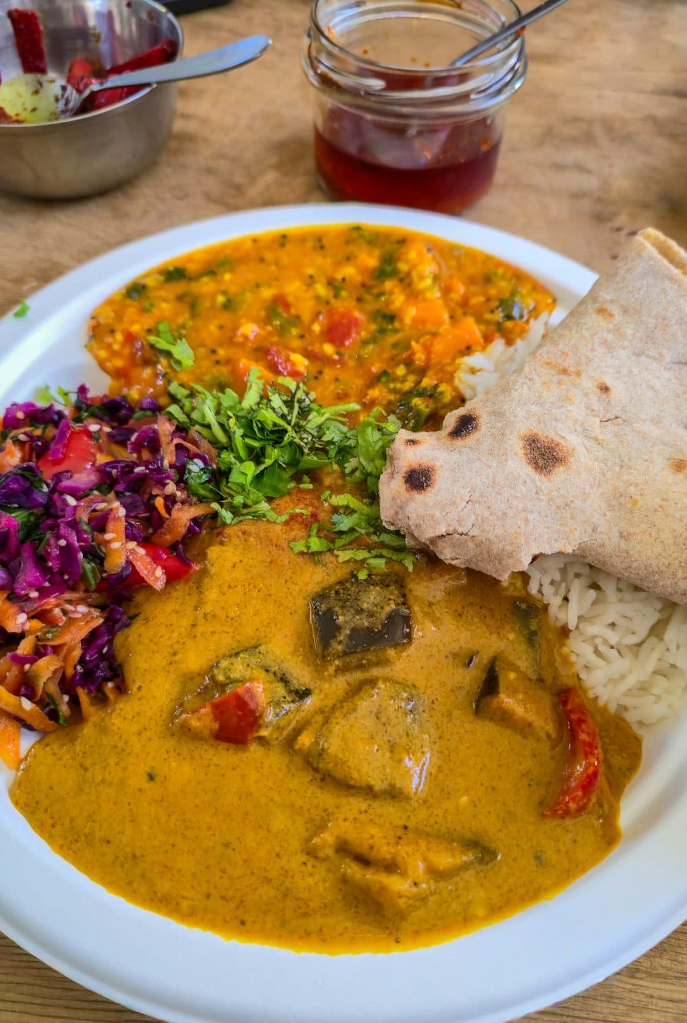 A plate of dal, vegetable curry, rice, a roti and a red cabbage salad